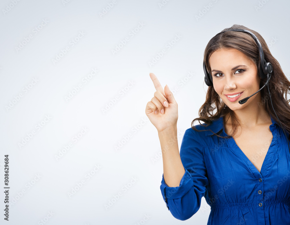 Portrait of happy smiling beautiful young support phone operator or sales agent, showing blank copy space area for slogan or text Portrait of happy smiling beautiful young support phone operator or sales agent, showing blank copy space area for slogan or text