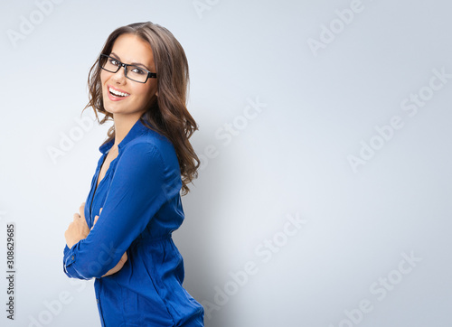 Portrait of smiling young businesswoman in glasses, corporate style, with blank copy space area for slogan or text photo