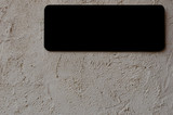 Black blank notice board with copy space on grey cement wall.
