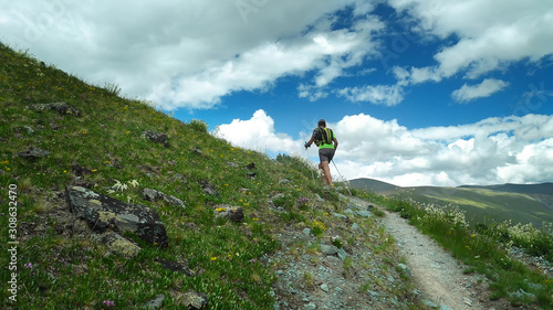 Trail runner climbing a stone trail to the mountain top. Ultra trail running, sport activities, mountain trails marathon.