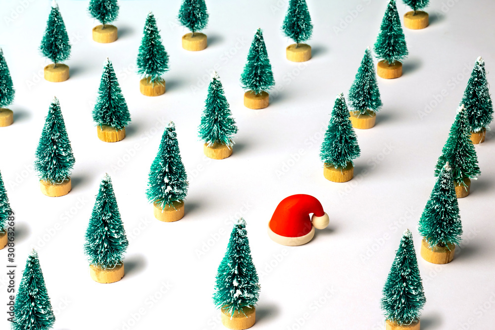 Christmas pattern made with pine trees and small rubber Santa Claus hat. Winter, Christmas, New Year concept.