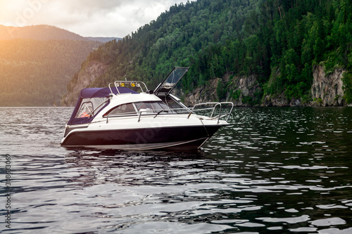 Obraz na płótnie A small pleasure boat with a motor for excursions and relaxation in picturesque places on the water and traveling on a river or lake with tourists