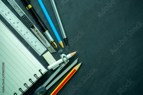 Stationery and notebook on blackboard. Concept of architecture office or back to school. Top view and copy space for text.