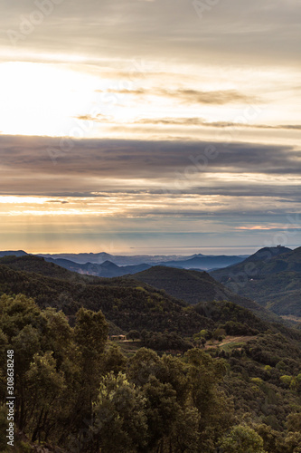 Fototapeta Naklejka Na Ścianę i Meble -  Brown cloudy sunrise on a green mountain landscape in Girona, Catalonia