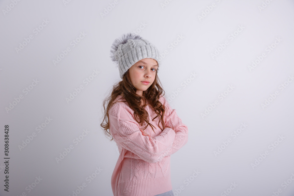portrait of a teenage girl in a winter knitted hat on a white background portrait of a teenage girl in a winter knitted hat on a white background