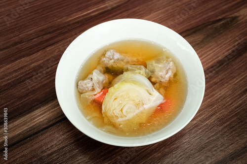 Cabbage clear soup with minced pork (Thai clear soup with vegetable) on dark brown wooden table.