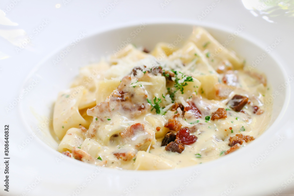 Fettucine carbonara pasta with fried bacon and grated cheese. Carbonara is an Italian pasta dish from Rome made with egg, hard cheese, pancetta and pepper. Fettucine carbonara pasta with fried bacon and grated cheese. Carbonara is an Italian pasta dish from Rome made with egg, hard cheese, pancetta and pepper.