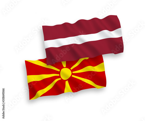 National vector fabric wave flags of Latvia and North Macedonia isolated on white background. 1 to 2 proportion.