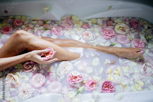 Beautiful girl in the bathroom with many flowers.