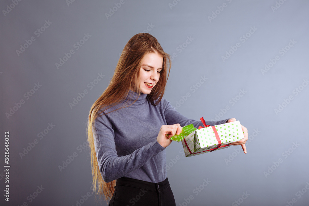 Image of happy girl opening and looking into gift box and wondering Image of happy girl opening and looking into gift box and wondering