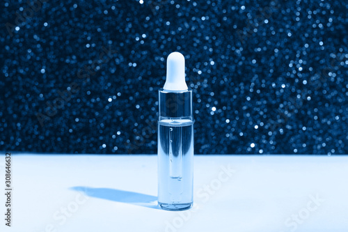 Dropper glass Bottle Mock-Up. Serum skin care cosmetics on blue glitter background