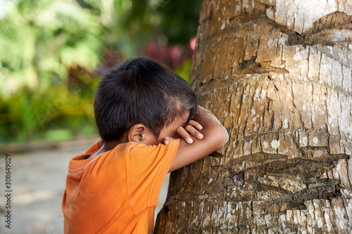 Filipino boy playing hide and seek at the beach of Palawan