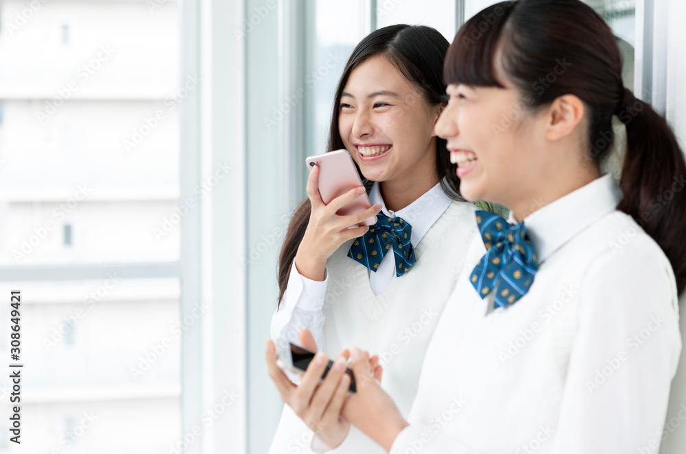 スマートフォンを持つ女子学生 スマートフォンを持つ女子学生