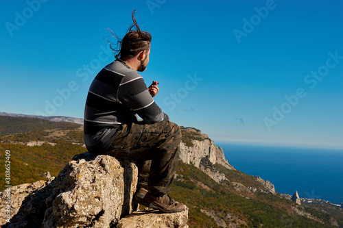 A man sitting on a top of a mountain