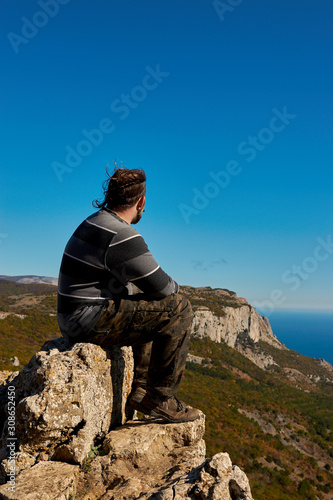 A man sitting on a top of a mountain