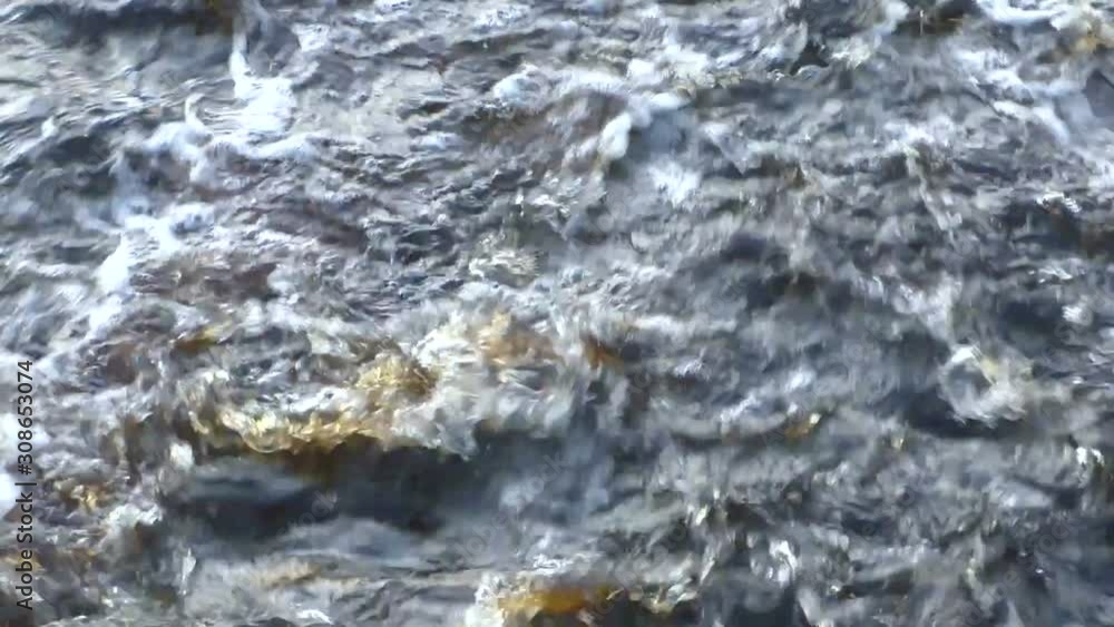 Current violent raging water. The river within the blue coolness breaks on the rapids.