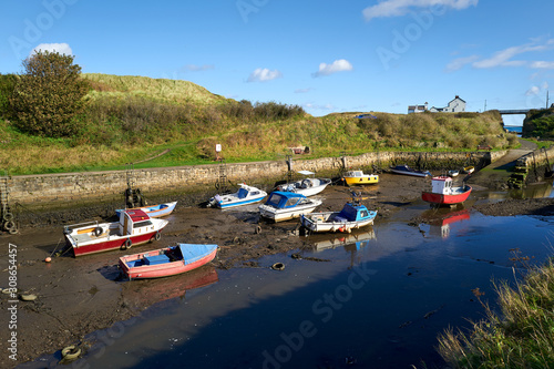 Fishing boats at low tide at the coastal village of Seaton Sluice harbour in Northumberland.