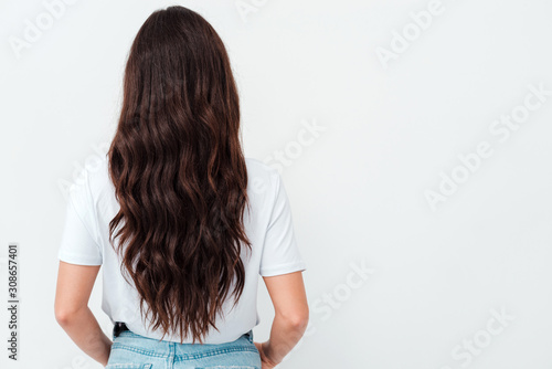 Back view of standing young beautiful brunette woman. girl watching. Isolated over white background.