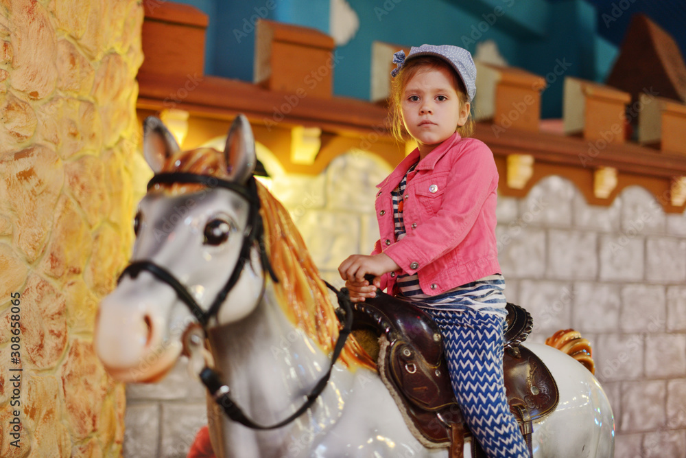 little  girl on the  carousel horse.