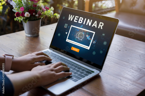 Person using a laptop computer for online training webinars. E-learning browsing connection and cloud online technology webcast concept. Laptop mockup with clipping path on screen.