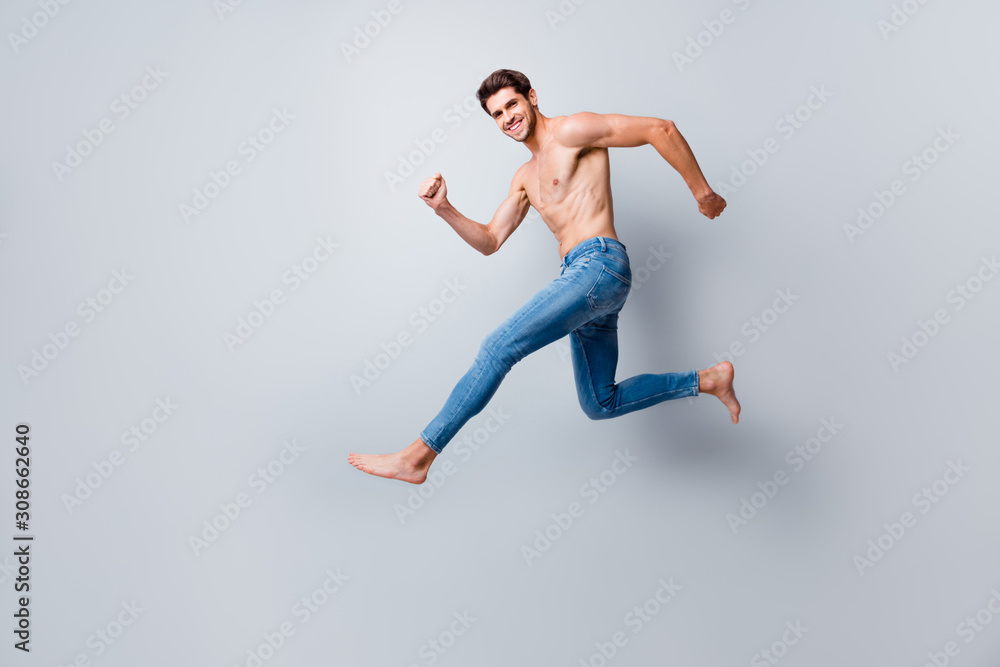 Full size profile photo of crazy macho man guy jumping high running topless torso metrosexual hot body competitive mood wear only jeans isolated grey background