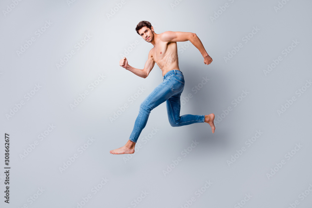 Full size profile photo of focused macho man guy jumping high running topless torso metrosexual hot body competitive mood wear only jeans isolated grey background