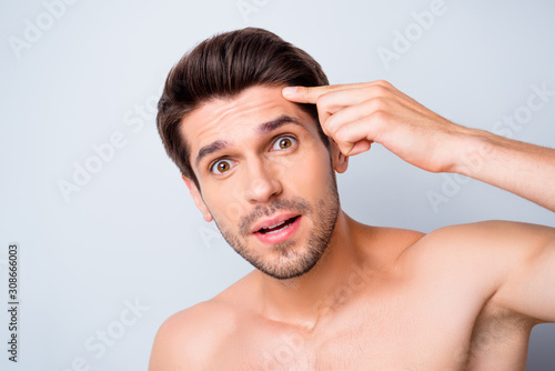 Closeup photo of macho model guy perfect neat hairstyle looking mirror touch forehead worried eyes want prevent wrinkles appear naked torso isolated grey background