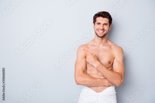 Portrait of handsome brown hair guy enjoy spa salon man skin body care treatment point index finger copyspace wear white towel isolated over grey color background