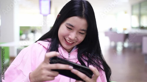 Beautiful Asian women are playing games with fun.young woman using digital tablet at home