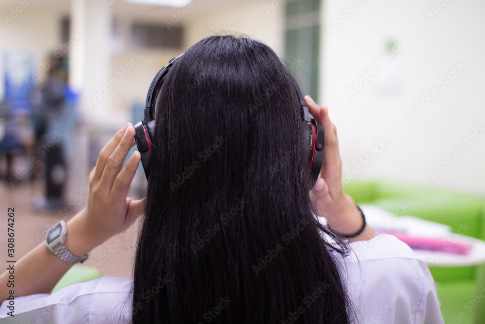 Fototapeta premium Women wear headphones to relieve stress, while working by listening to music.