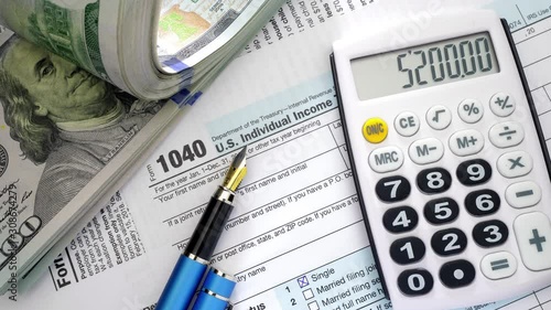 USA Tax Form 1040 and dollar bills, close up. High angle view.