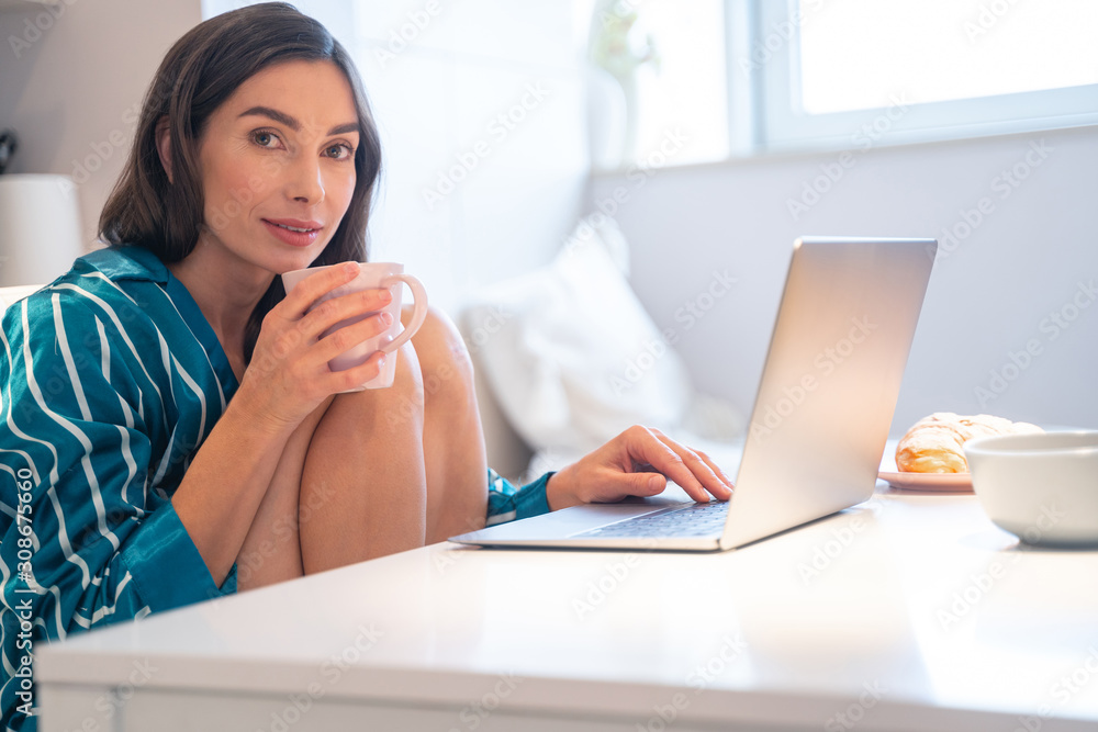Obraz premium Hot tea and laptop at the weekend at home stock photo