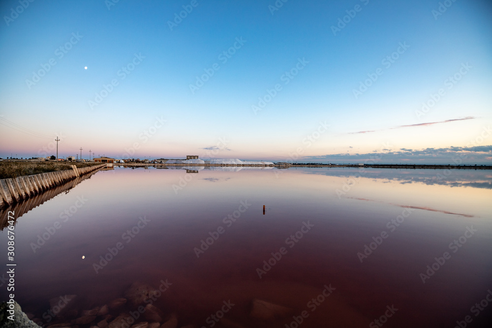 Nature reserve Saline Margherita di Savoia, Apulia, Italy: Salt flats, salt pan area for salt production. colored red waters from the alga Dunaliella salina. Salt and the moon reflected in the marsh Nature reserve Saline Margherita di Savoia, Apulia, Italy: Salt flats, salt pan area for salt production. colored red waters from the alga Dunaliella salina. Salt and the moon reflected in the marsh