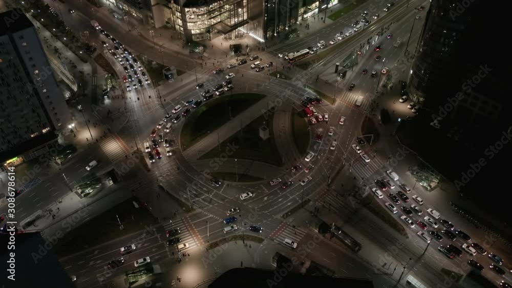 Aerial view of a roundabout at night with car traffic. Drone shot on the night highway in the business center of Warsaw. Aerial view of a roundabout at night with car traffic. Drone shot on the night highway in the business center of Warsaw.