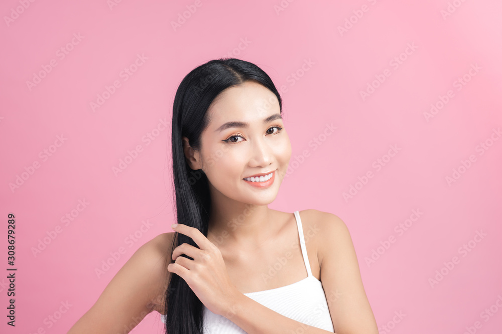 Young beautiful Asian woman taking care of her hair. Beauty portrait , natural make-up, beauty face, isolated over pink background. Young beautiful Asian woman taking care of her hair. Beauty portrait , natural make-up, beauty face, isolated over pink background.
