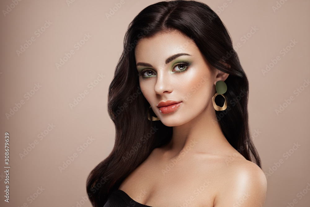 Beautiful woman with long curly hair. Girl with perfect makeup and hairstyle. Model brunette with perfect healthy dark hair. Fashion photo