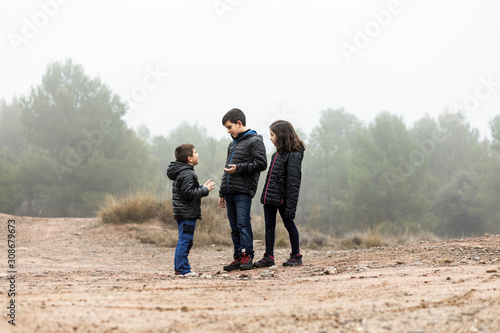 Three kids in the middle of a foggy field