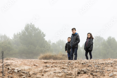 Three kids in the middle of a foggy field