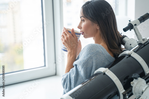 Free Download Calm lady with tea and telescope at home stock photo - GFXLoad