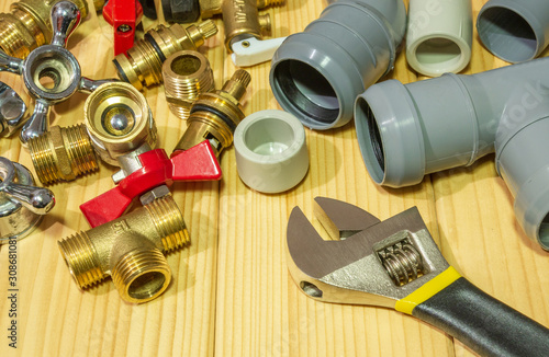 Spare parts and accessories for plumbing repair on a wooden background