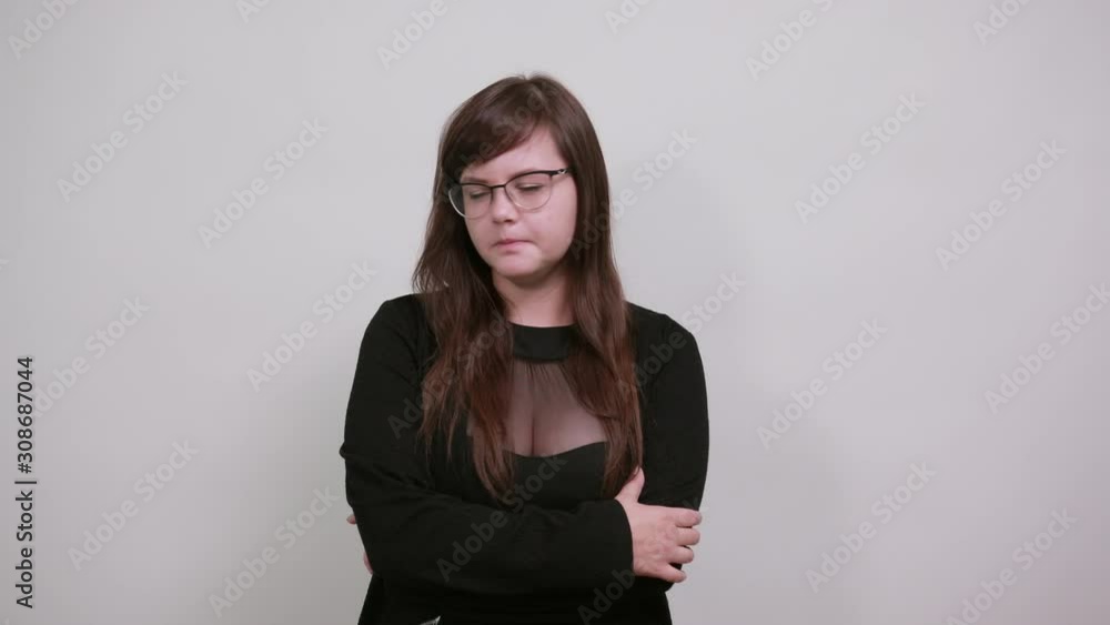Side view of successful confident young woman in nice casual dress holding hands crossed, opened eyes over isolated on gray wall background in studio. People lifestyle concept. Side view of successful confident young woman in nice casual dress holding hands crossed, opened eyes over isolated on gray wall background in studio. People lifestyle concept.