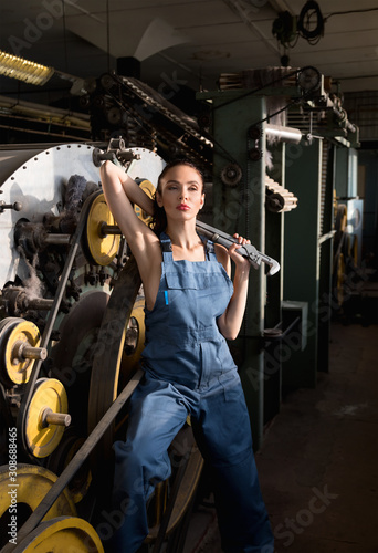 Beautiful brunette girl with a big pipe wrench