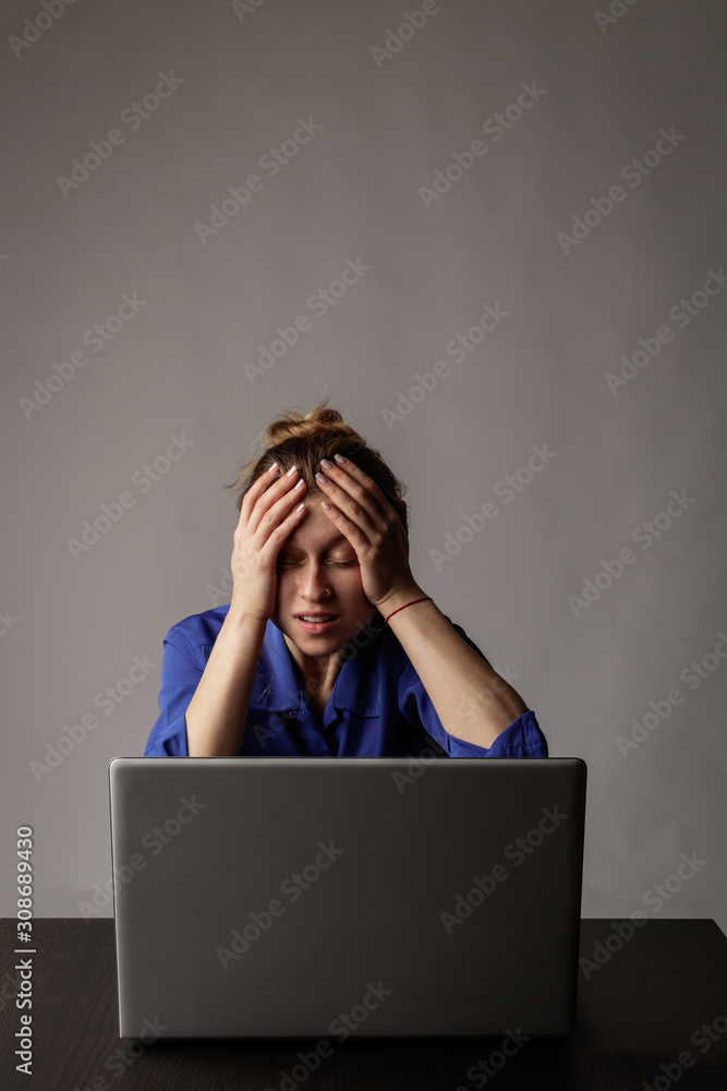 Young woman in blue with laptop. Overwork. Young woman in blue with laptop. Overwork.