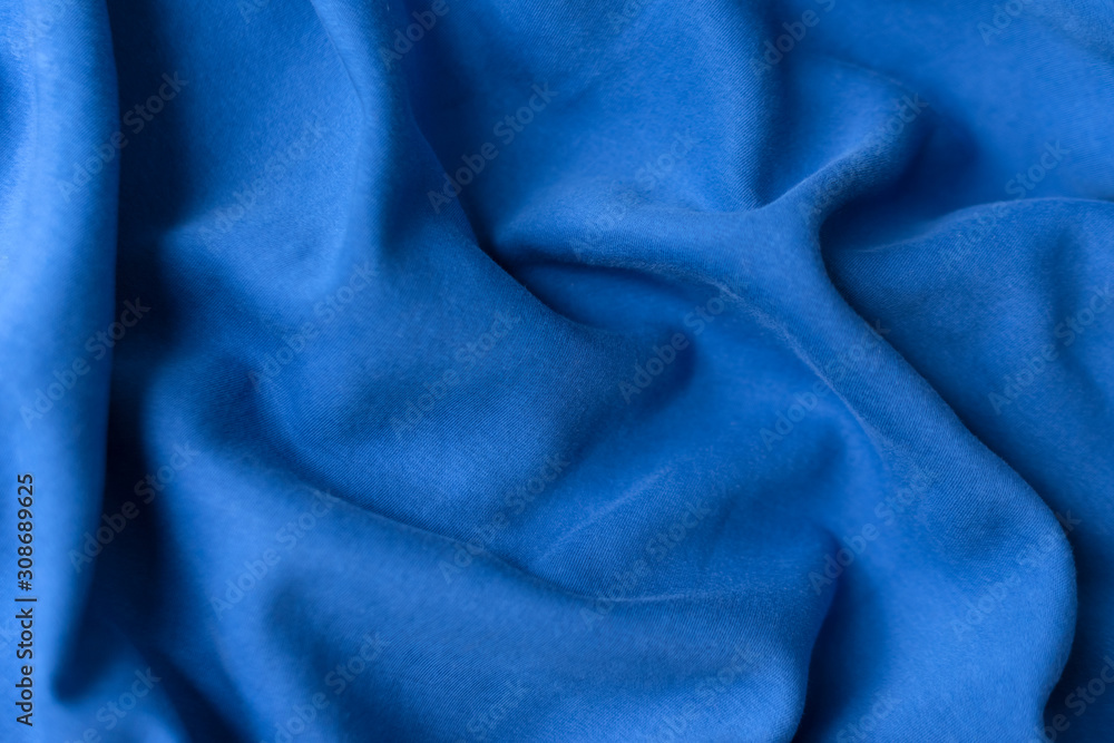 Fototapeta premium Blue fabric texture background. Textile cloth colored in trend classic blue color of the year 2020. Classic Blue Pantone color. Shallow depth of field, selective focus
