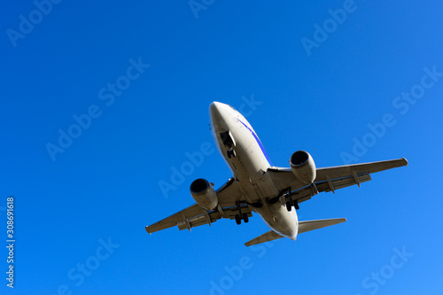 Overhead aircraft landing with blue sky