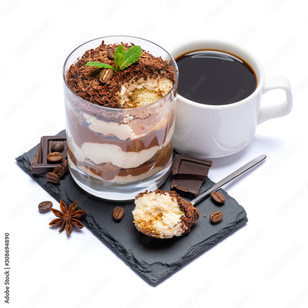 Classic tiramisu dessert in a glass cup and pieces of chocolate on stone cutting board on white background with clipping path Classic tiramisu dessert in a glass cup and pieces of chocolate on stone cutting board on white background with clipping path