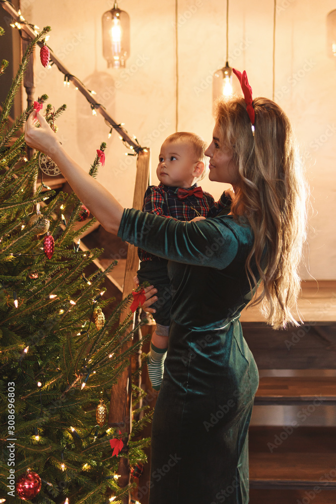 Happy mother and her cute little son are celebrating Christmas or New year.