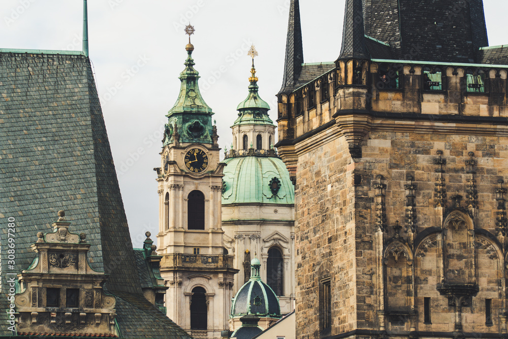 Close tight shot of Lesser Town Bridge Tower and The Church of Saint Nicholas (Malá Strana), Baroque church in the Lesser Town of Prague in the background between the towers