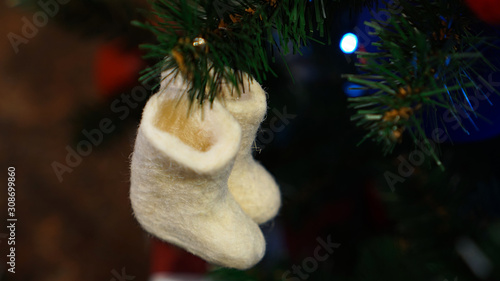 Christmas decorations on the Christmas tree. White felt boots.	