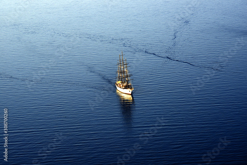 Large four-masted sailboat in the middle of the blue sea level photo